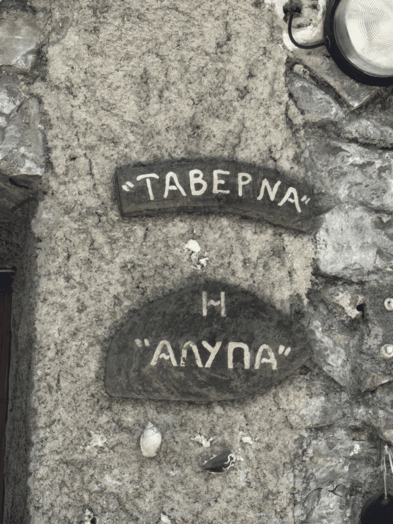 Stone sign with Greek letters for a tavern named 'Alina'.