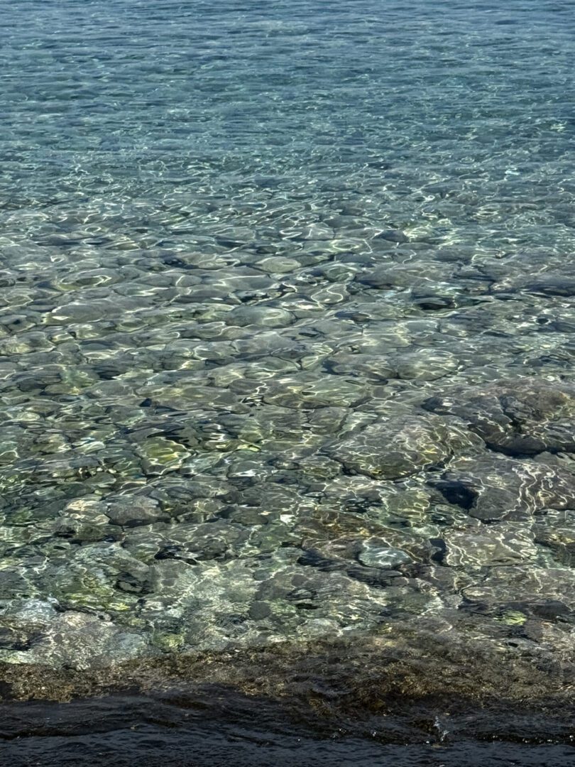 Clear, shallow water over a rocky seabed.