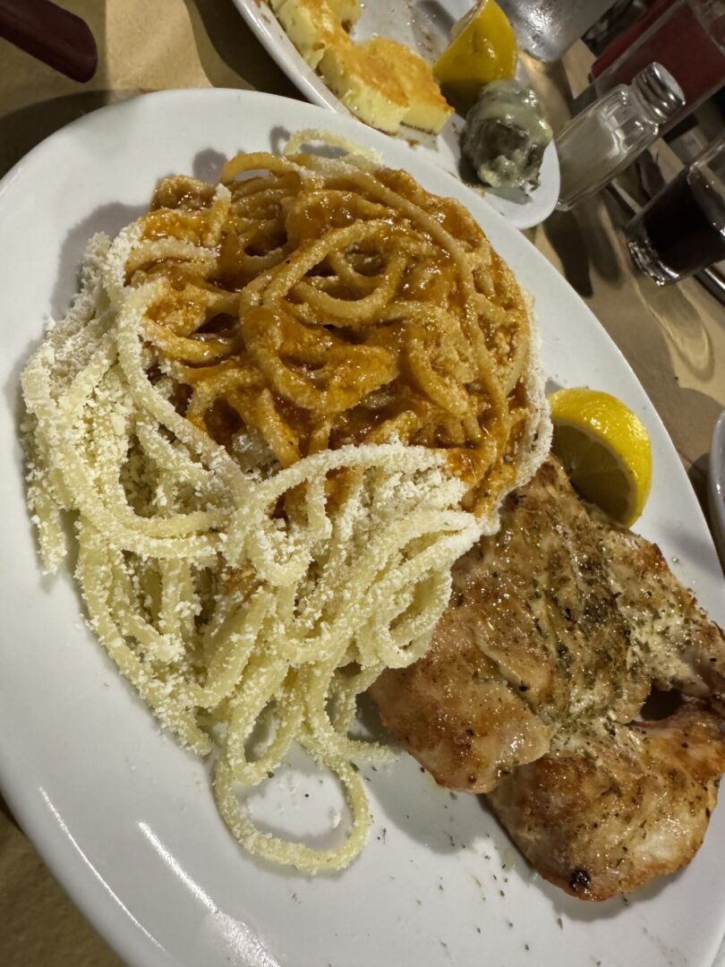 A plate with fried chicken, crispy curly fries, and puffed snacks.
