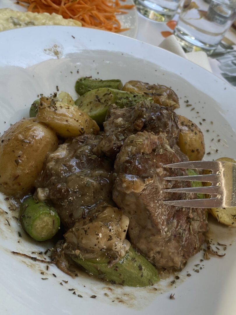 Plate with roasted meat, potatoes, and vegetables, covered in gravy.