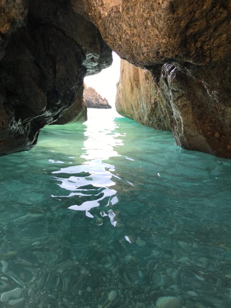 Clear turquoise water flowing between rocky cliffs.