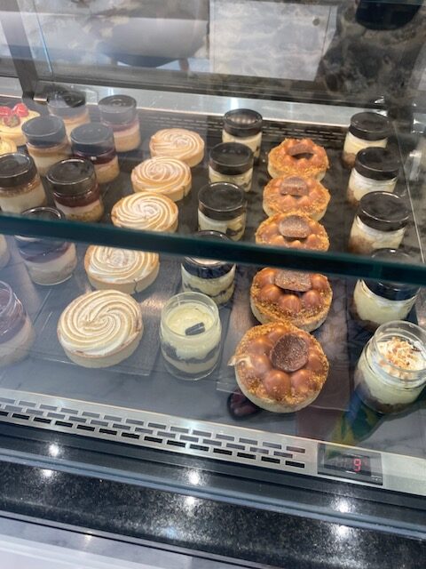 A variety of desserts displayed in a glass case.