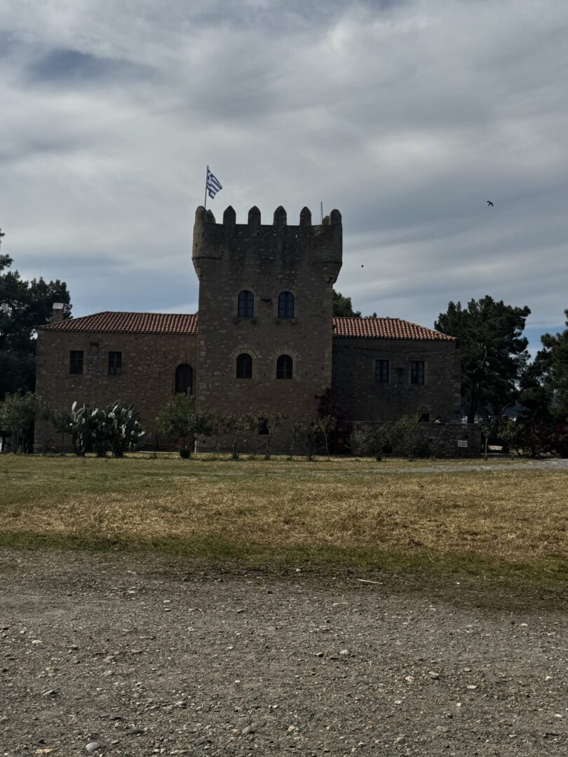 Historic stone castle with battlements under a cloudy sky.