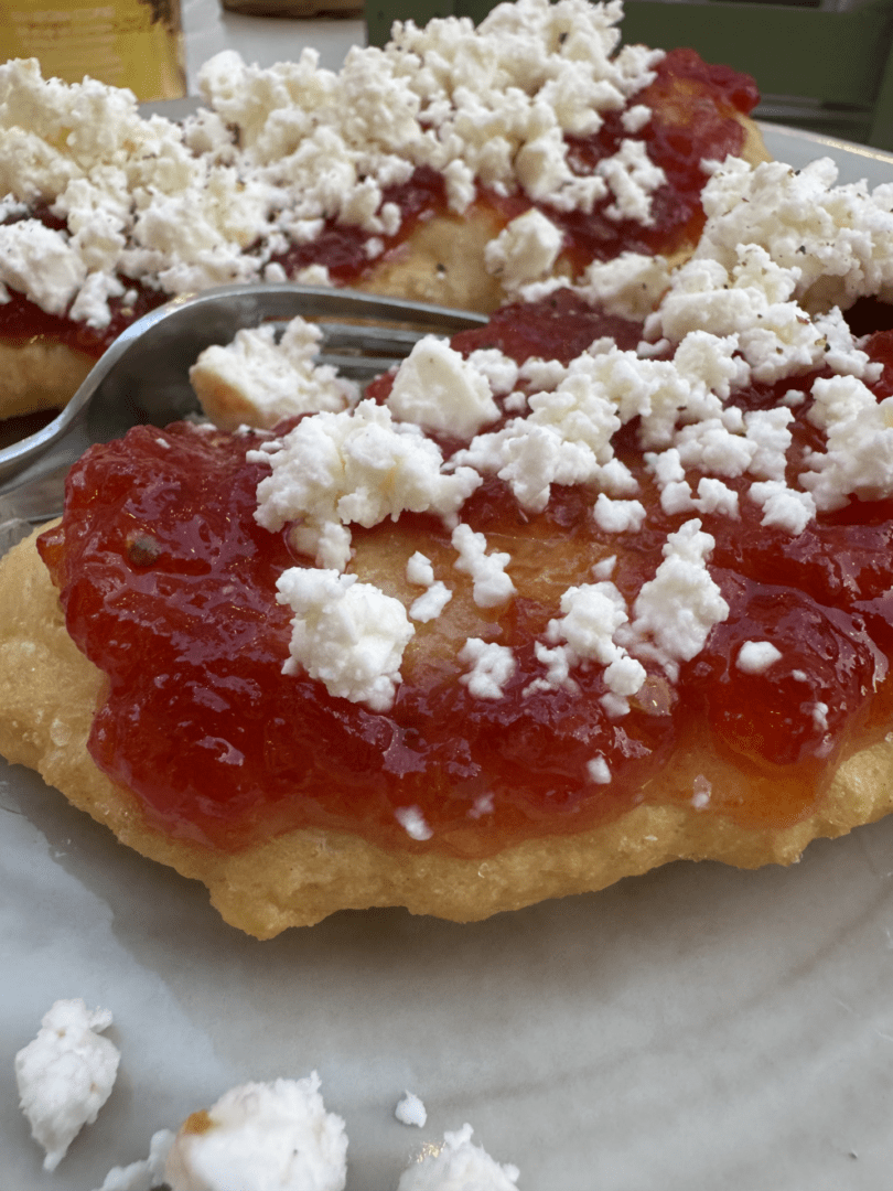 Close-up of a biscuit with red jam and crumbled white cheese.