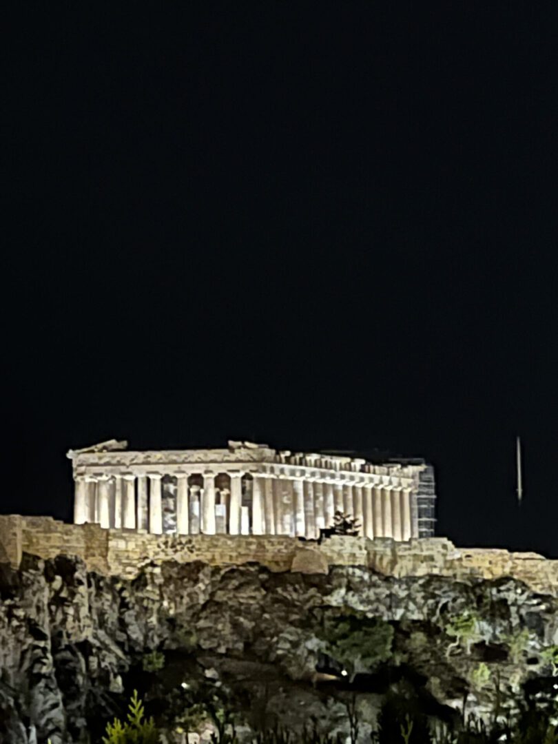 The illuminated Parthenon at night against a dark sky.